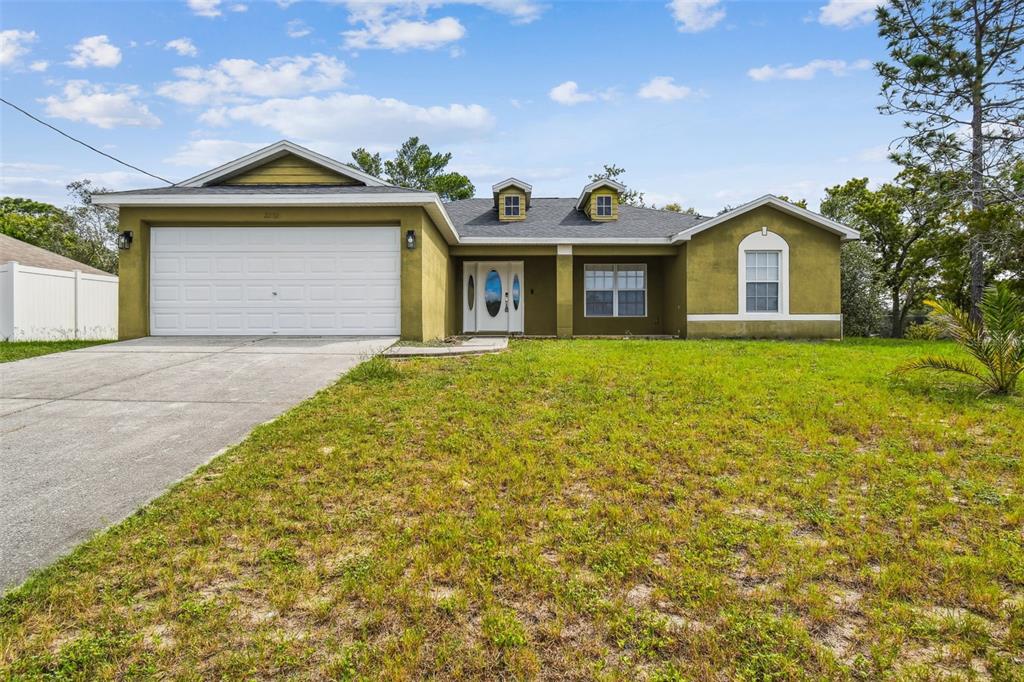 2222 Champlain Avenue Spring Hill, FL 34609 - Photo 3 of 74 a front view of a house with a yard and garage