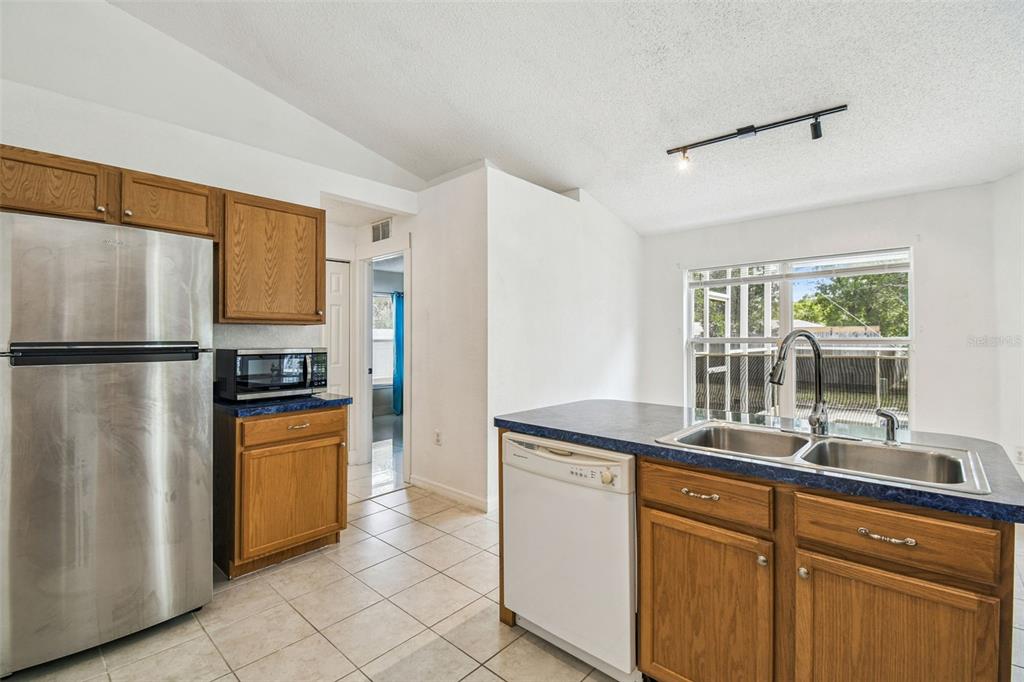 2222 Champlain Avenue Spring Hill, FL 34609 - Photo 33 of 74 a kitchen with stainless steel appliances granite countertop a refrigerator and a sink