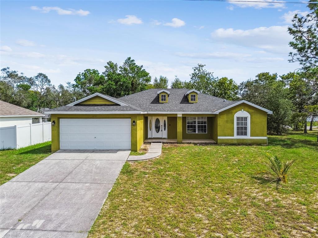 2222 Champlain Avenue Spring Hill, FL 34609 - Photo 55 of 74 a front view of a house with garden