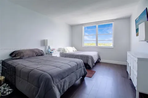 a bedroom with two beds lamp and a window