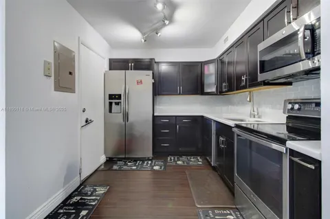 a kitchen with stainless steel appliances granite countertop a refrigerator and a stove top oven
