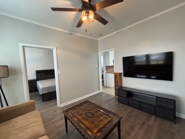 a bedroom with a bed television on desk and a window