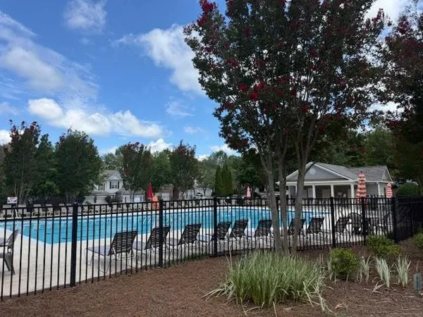 a sign board with a yard and buildings