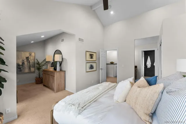 a bedroom with a large bed and a large mirror