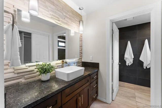 a bathroom with a granite countertop sink and a mirror
