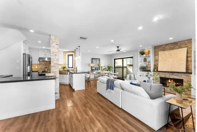 a living room with furniture kitchen view and a large window