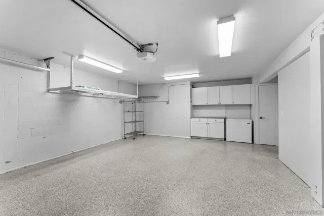 a view of empty room with wooden cabinet and windows