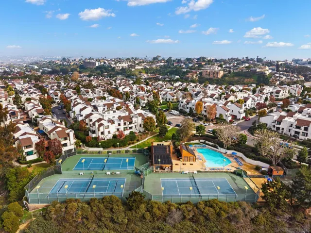 an aerial view of residential houses with outdoor space and swimming pool