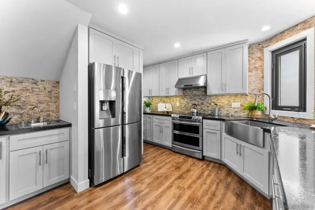 a kitchen with white cabinets and stainless steel appliances