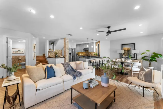 a living room with lots of furniture and view of kitchen