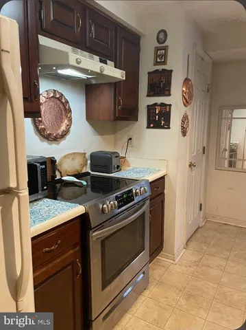 a kitchen with stainless steel appliances granite countertop a stove and a wooden cabinets