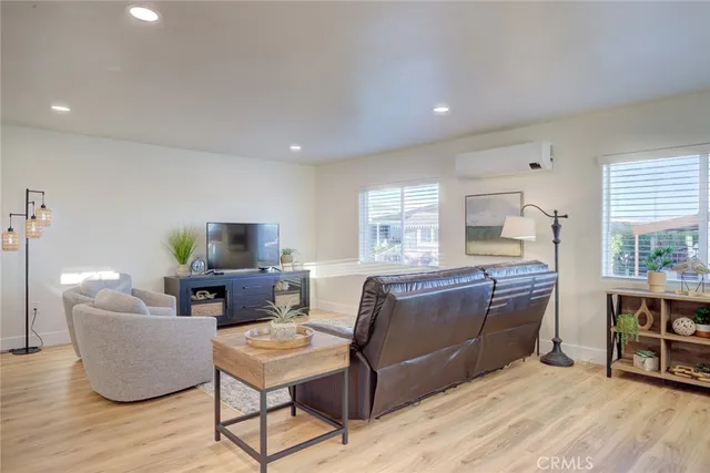 a living room with furniture a flat screen tv and kitchen view