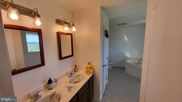 a en suite bathroom with a double vanity sink and a mirror