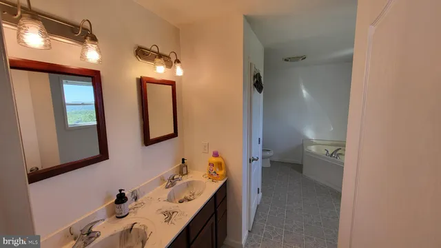 a en suite bathroom with a double vanity sink and a mirror