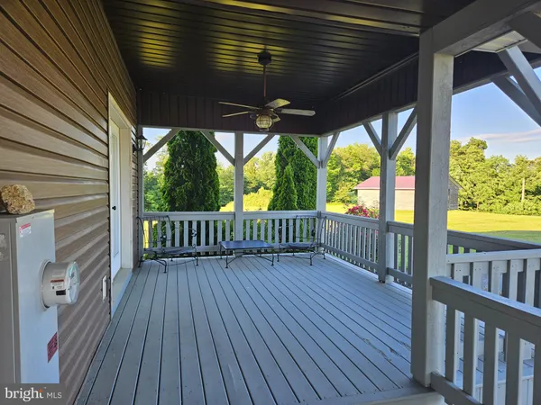 a view of a porch with wooden floor in front of a house