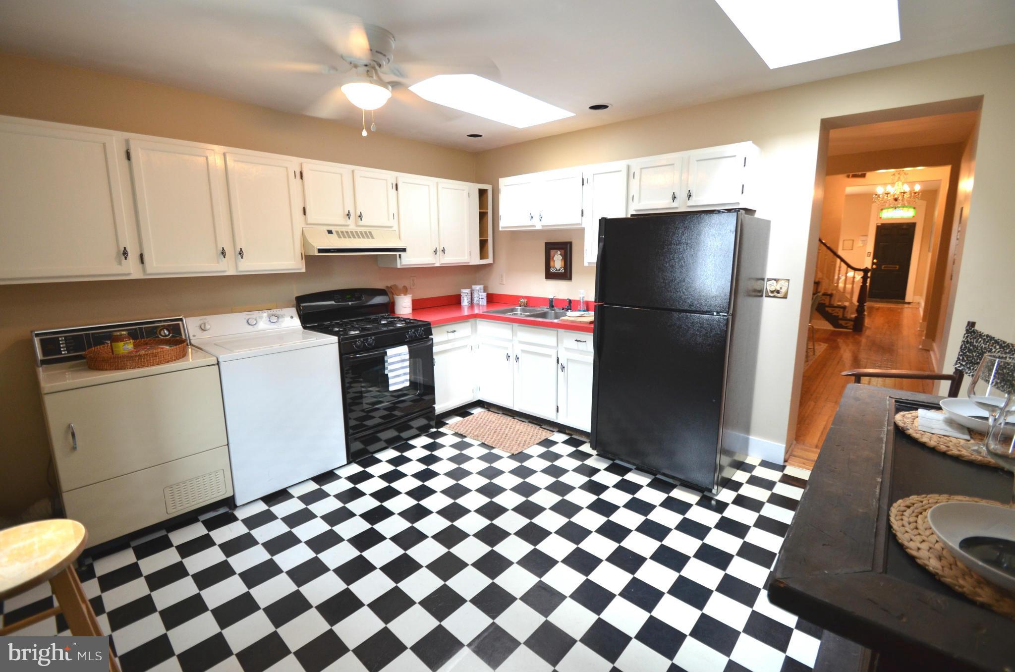 2309 Eastern Avenue Baltimore, MD 21224 - Photo 5 of 30 a kitchen with a sink a refrigerator and cabinets