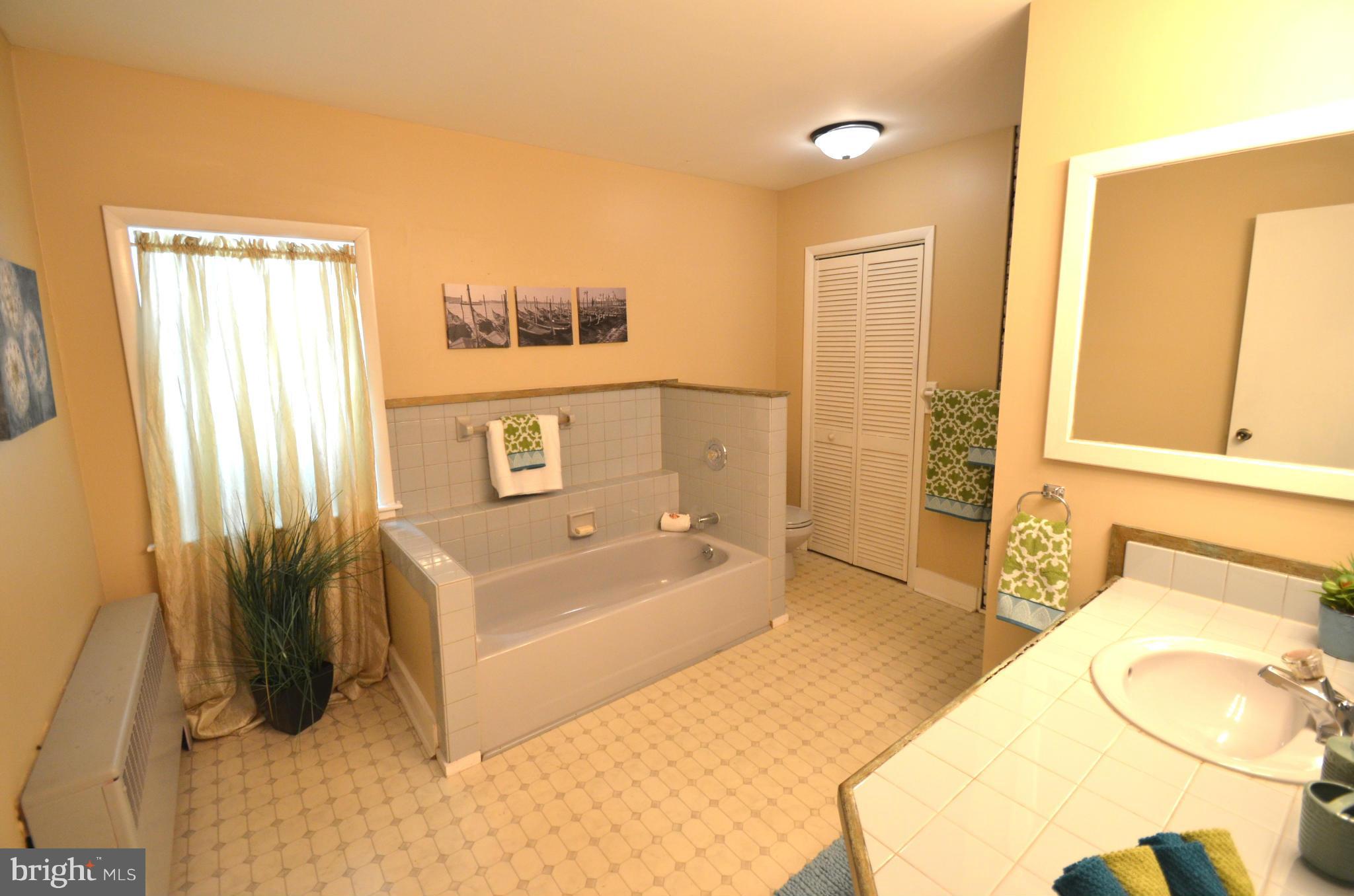 2309 Eastern Avenue Baltimore, MD 21224 - Photo 8 of 30 a spacious bathroom with a tub sink and mirror