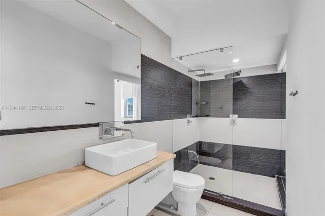 a bathroom with a sink a toilet and mirror