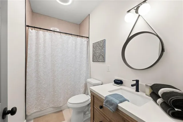 a bathroom with a sink mirror vanity and toilet