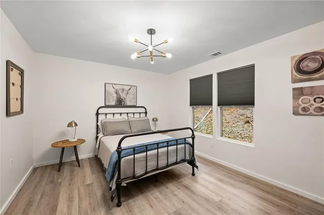 a bedroom with a bed chandelier and a window