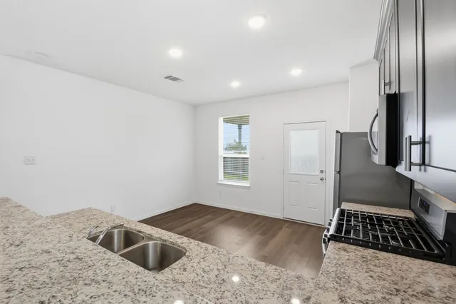 a view of kitchen with sink refrigerator and microwave