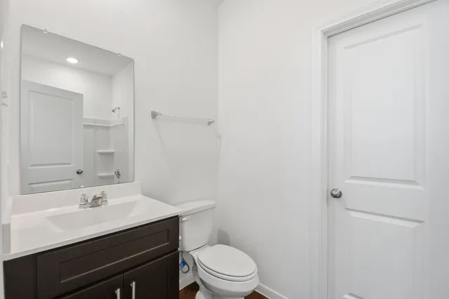 a bathroom with a sink vanity mirror and toilet
