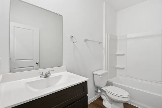 a bathroom with a sink a toilet a shower and a mirror