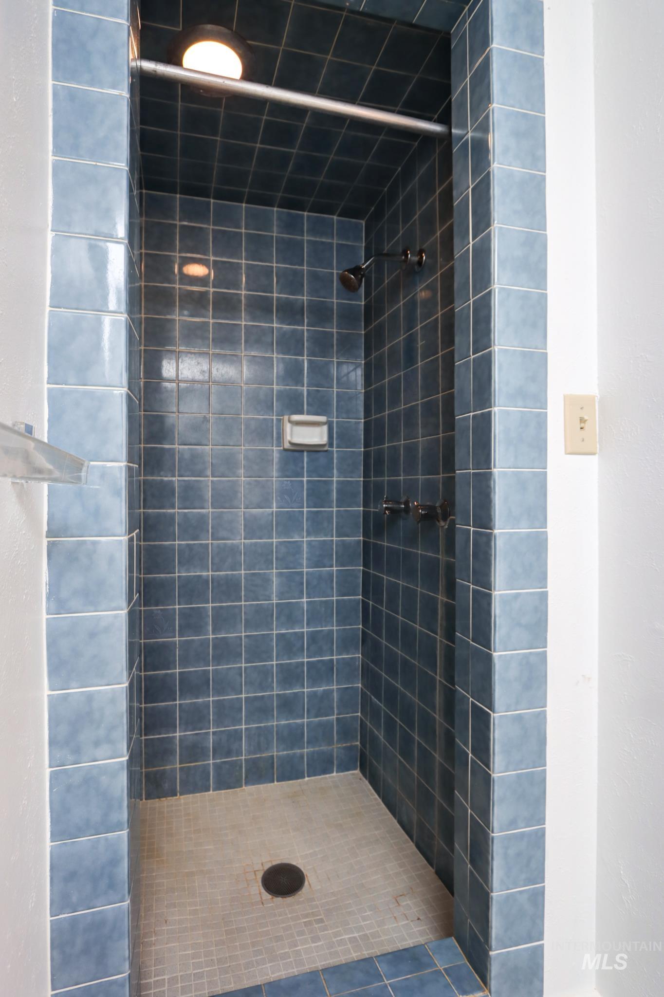801 Thompson Avenue Nyssa, OR 97913 - Photo 32 of 46 Tiled shower stall featuring blue square wall tiles and light-colored square floor tiles