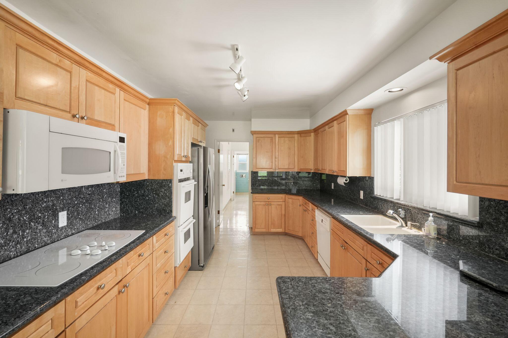 108 West Kenneth Road Glendale, CA 91202 - Photo 35 of 47 a large kitchen with stainless steel appliances granite countertop a sink stove and refrigerator