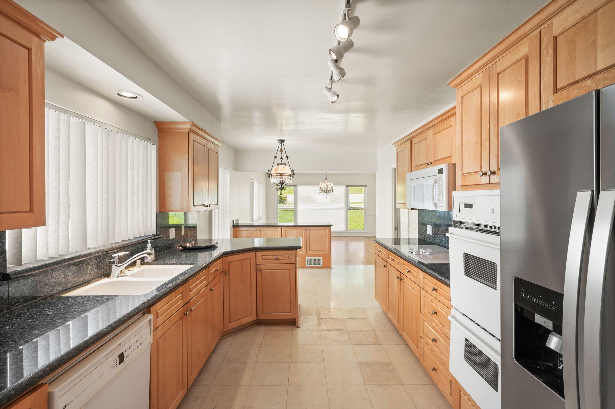 108 West Kenneth Road Glendale, CA 91202 - Photo 37 of 47 a large kitchen with stainless steel appliances granite countertop a refrigerator a sink dishwasher a stove and a dining table view