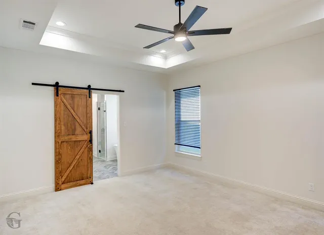 an empty room with windows and fan
