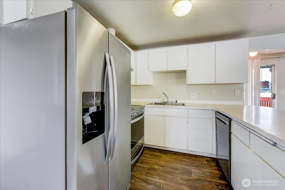 6629 204th Street Southwest Lynnwood, WA 98036 - Photo 6 of 17 a kitchen with stainless steel appliances granite countertop a refrigerator sink and white cabinets