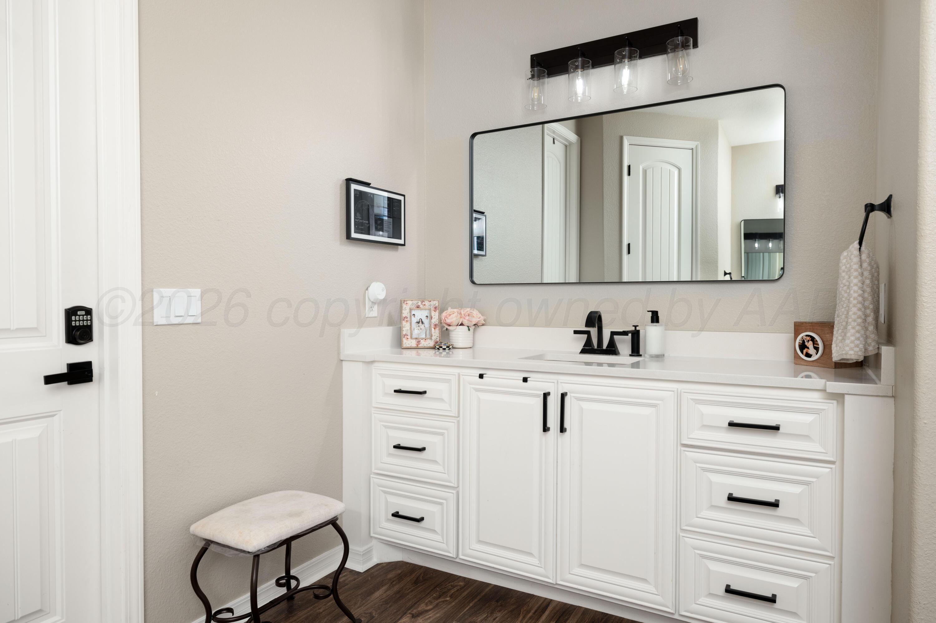 15201 Helium Road Amarillo, TX 79119 - Photo 23 of 61 a bathroom with a sink a toilet a mirror and shower