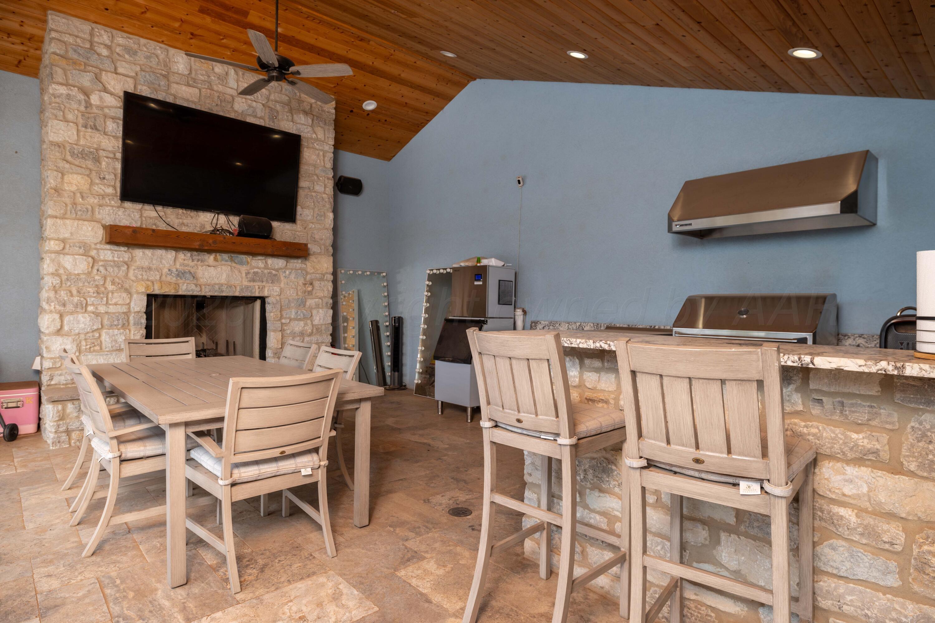 15201 Helium Road Amarillo, TX 79119 - Photo 49 of 61 a dining room with furniture a fireplace and a flat screen tv