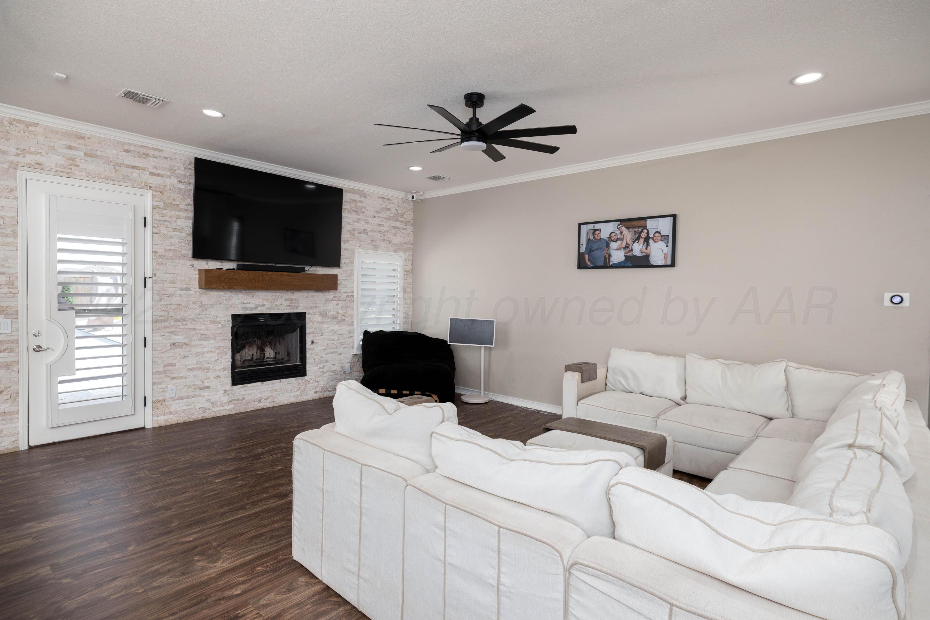 15201 Helium Road Amarillo, TX 79119 - Photo 8 of 61 a living room with furniture a fireplace and a flat screen tv