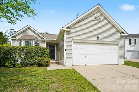 a view of a house with a small yard and a garage