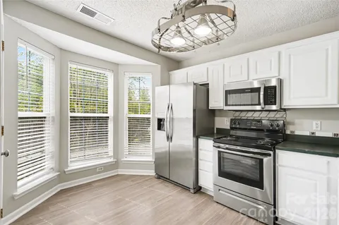 a kitchen with a stove a microwave and window