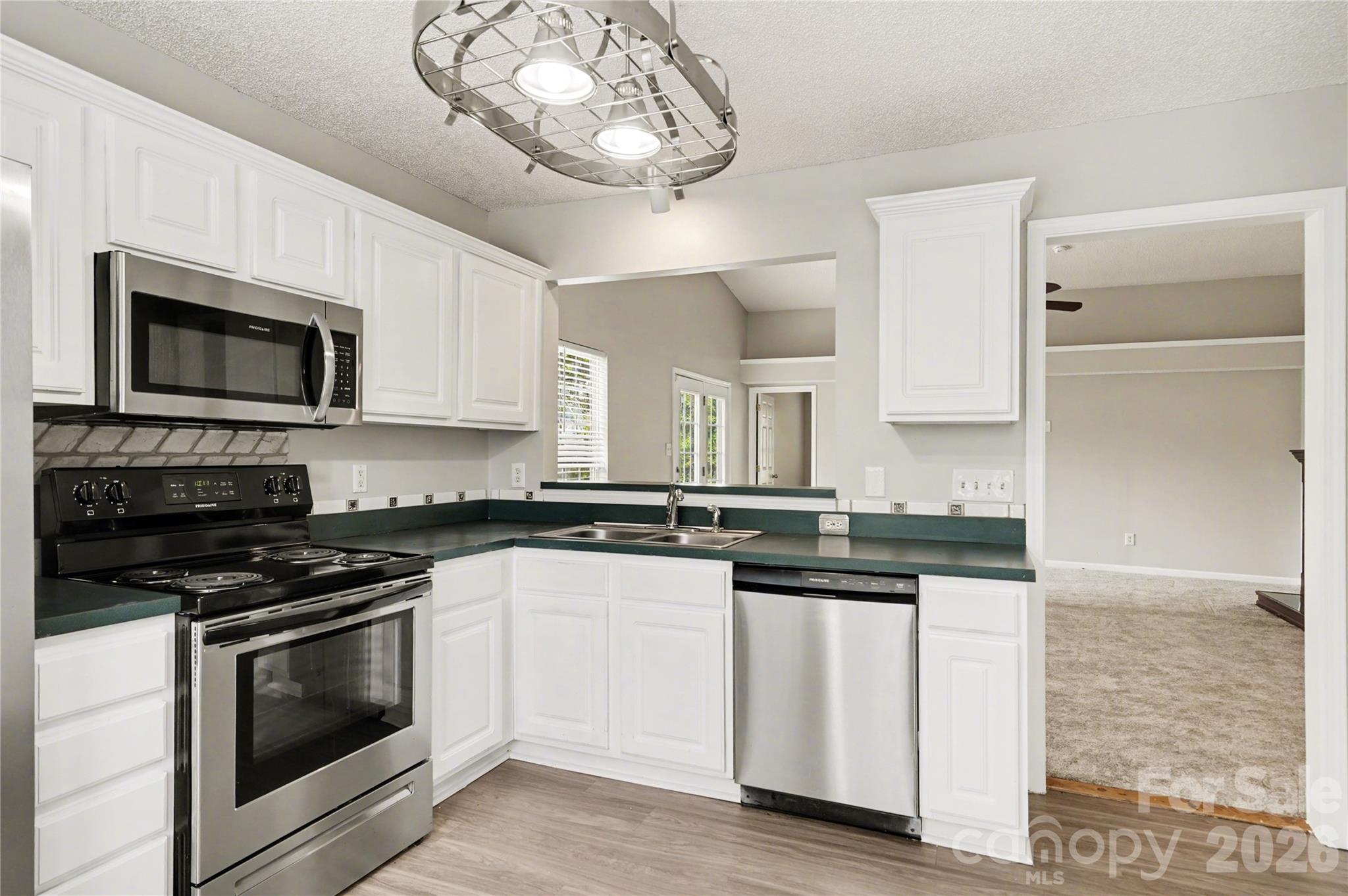 117 North Tanninger Road Mount Holly, NC 28120 - Photo 4 of 10 a kitchen with stainless steel appliances granite countertop a stove and a microwave
