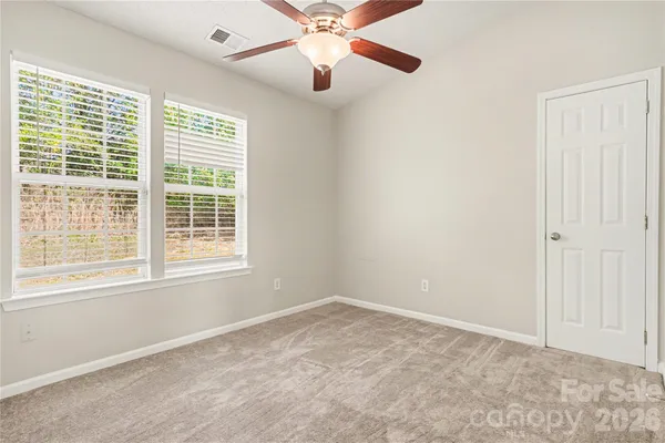an empty room with a window and a fan