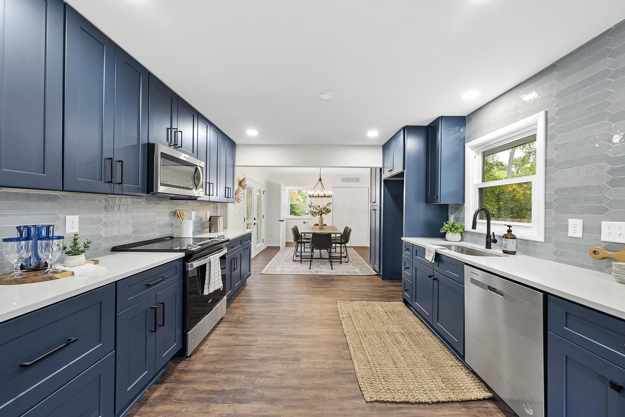 3128 Brentwood Road Raleigh, NC 27604 - Photo 10 of 28 a large kitchen with stainless steel appliances granite countertop a stove top oven a sink dishwasher and cabinets with wooden floor