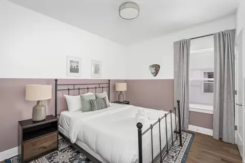 a bedroom with a bed and wooden floor