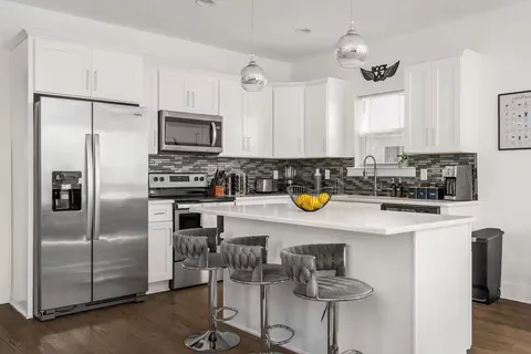 a kitchen with a refrigerator and a stove top oven
