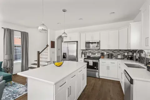 a kitchen that has a lot of cabinets a sink and appliances