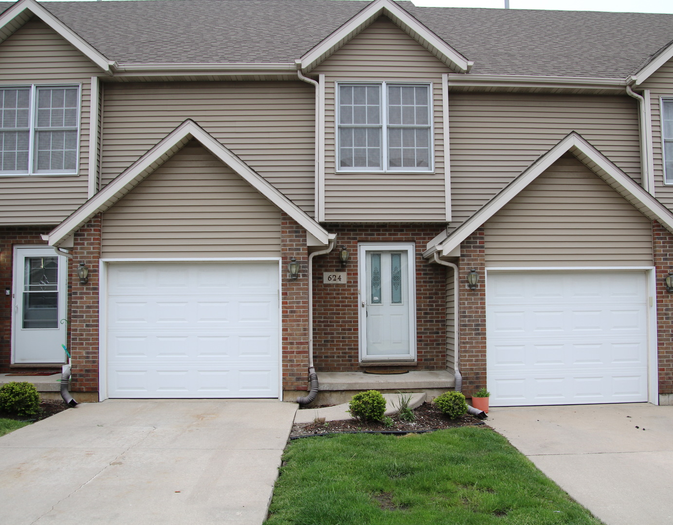 624 South Peace Road, Unit 624 Sycamore, IL 60178 - Photo 2 of 14 a front view of a house with a garden and garage