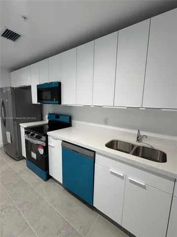 a kitchen with stainless steel appliances granite countertop a sink and a stove
