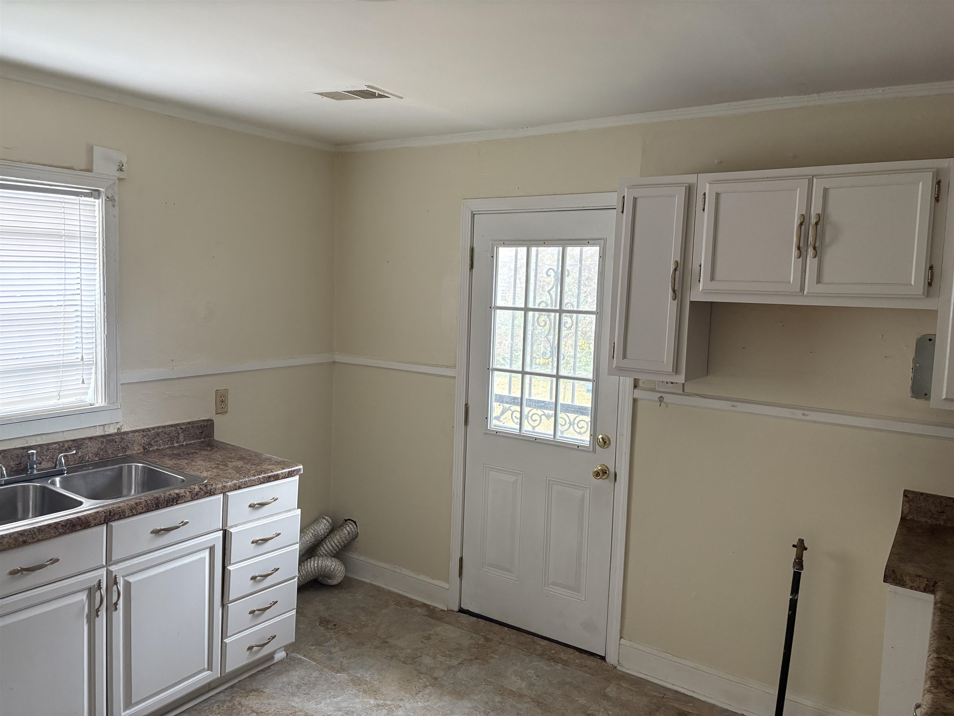 1509 Ragan Street Memphis, TN 38106 - Photo 13 of 17 Kitchen featuring white cabinets, dark countertops, and crown molding