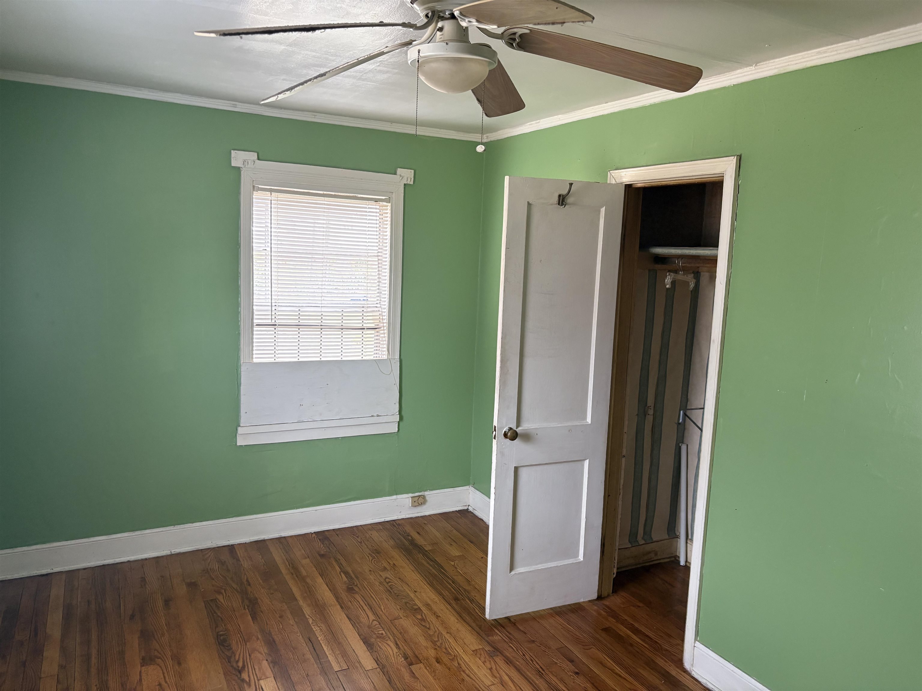 1509 Ragan Street Memphis, TN 38106 - Photo 6 of 17 Unfurnished bedroom with crown molding, dark wood-type flooring, a ceiling fan, and a closet