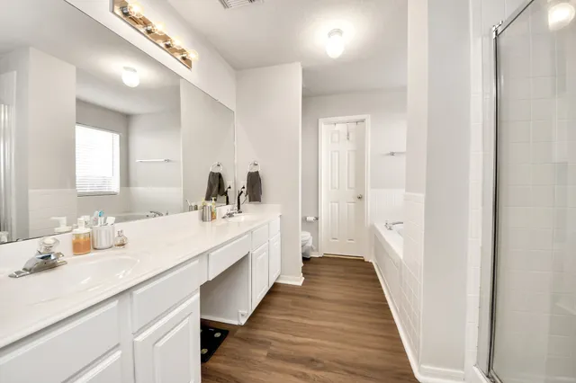 a en suite bathroom with a double vanity sink and a mirror