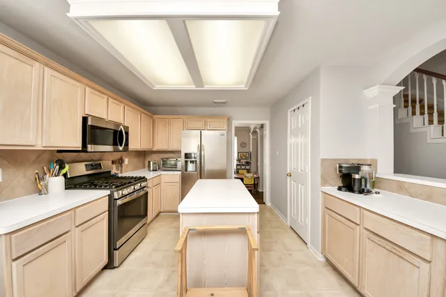 a kitchen with stainless steel appliances granite countertop a sink stove microwave and refrigerator