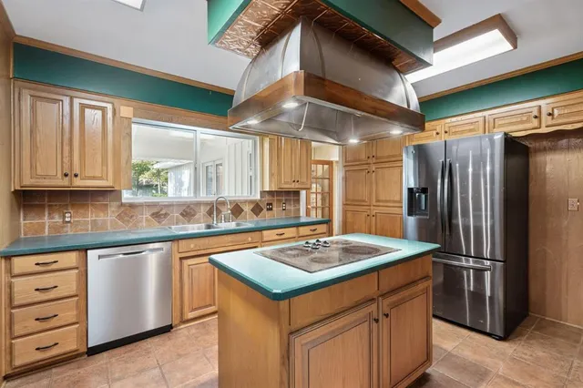 a kitchen with stainless steel appliances granite countertop a refrigerator and a stove